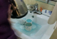 Nhân viên buồng phòng dùng nước rửa toa-lét để rửa chén